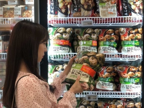 한 소비자가 서울의 한 대형마트에 진열된 풀무원식품 얇은피꽉찬속 만두를 유심히 들여다보고 있다./사진제공=풀무원
