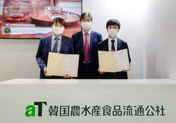 aT 장서경 일본지역본부장(가운데), 일본바이어사 관계자(오른쪽), 농협인터내셔널 김진호 사장(왼쪽)이 신선 참외 현장 수출계약 MOU를 맺고 기념사진을 찍고 있다. /사진제공=aT