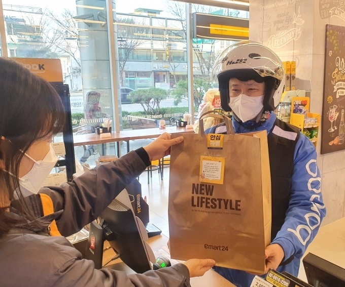 이마트24 매장에서 배달원이 상품을 건네받고 있다 / 사진제공=이마트24