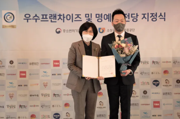 지난 25일 소상공인시장진흥공단 황미애 본부장(왼쪽)과 이차돌 조준환 기획조정이사가 롯데 호텔 서울에서 열린 ‘2021 우수프랜차이즈 지정식’에서 수상 후 기념 사진을 촬영하고 있다.