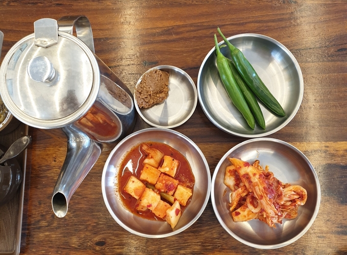 매장에서 직접 담근 김치, 깍두기와 풋고추로 구성된 밑반찬 3종과 따뜻한 둥글레차