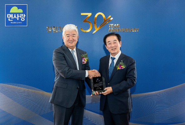 사진: ㈜면사랑의 30년에 걸친 진천군 지역 발전 공헌에 대한 감사패 수여 후 ㈜면사랑 정세장 대표(좌)와 송기섭 진천군수(우)가 악수를 나누고 있다.