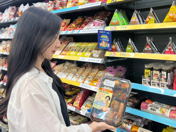 사진=GS25에서 모델이 ‘혜자롭게 돌아온 명불허전’ 도시락을 선보이고 있다