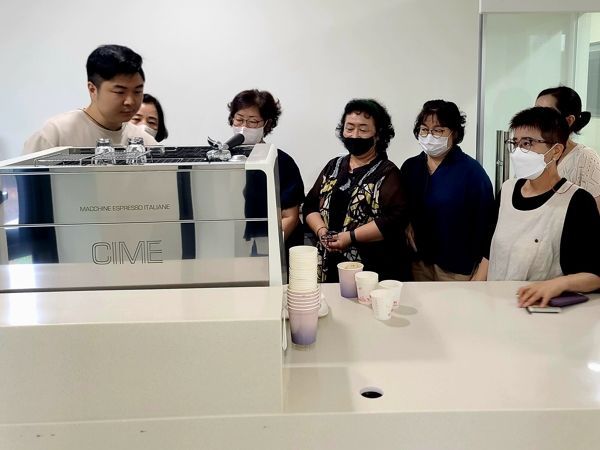 카페 나누다에서 근무할 어르신 바리스타들이 기기 작동법을 배우고 있다